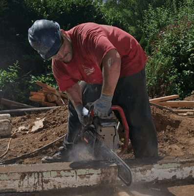 Walk-behind flat saw cutting through reinforced concrete on a jobsite