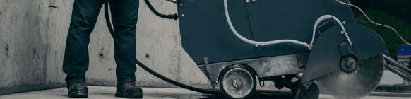Walk-behind flat saw cutting concrete on an active construction site